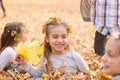 Children are lying and playing on fallen leaves in autumn city park. Royalty Free Stock Photo