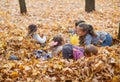 Children are lying and playing on fallen leaves in autumn city park Royalty Free Stock Photo