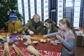 Children making Christmas ornaments with straw, an old woman teaching