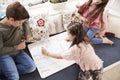 Children Making List Of Chores On Whiteboard At Home