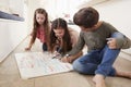 Children Making List Of Chores On Whiteboard At Home