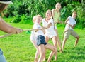 Children with moms and dads playing tug of war Royalty Free Stock Photo