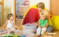 Children and mother collecting toys