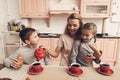 Children with mother in kitchen. Family is drinking tea with croissants. Royalty Free Stock Photo