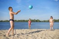Children with mother playing with a volleyball ball on the river Bank Royalty Free Stock Photo