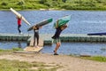 Children move kayaks from water to coast after rowing training.