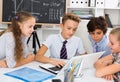 Children near laptop talking about mathematics