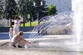 Children near a splashing fontain in the center of town