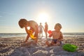 Children need the freedom and time to play. two little boys playing on the beach with their parents in the background. Royalty Free Stock Photo