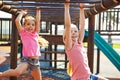 Children need the freedom and time to play. two little girls hanging on the monkey bars at the playground.