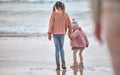 Children, ocean and holding hands sisters standing on sea sand, relax and watching waves together on vacation. Freedom Royalty Free Stock Photo