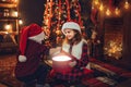 Children open magic giftbox near fireplace and christmas tree. New Year concept. Christmas time Royalty Free Stock Photo