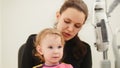 Children ophthalmology - mother and cute little girl - optometrist Checks Child`s Eye