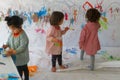 Children paint using watercolors inside their classroom