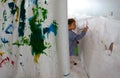 Children paint using watercolors inside their classroom