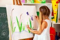 Children painting finger on easel. Group of kids with teacher. Royalty Free Stock Photo