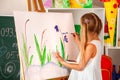 Children painting finger on easel. Group of kids with teacher. Royalty Free Stock Photo