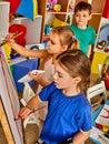 Children painting finger on easel. Group of kids with teacher.