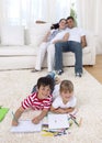 Children painting on floor in living-room