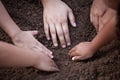 Children and parent helping prepare soil for planting together