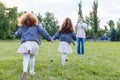 Children with parents in the park. Cute family haming fun in nature. Twin toddler sisters holding parents. Happy family concept
