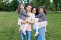 Children with parents in the park. Cute family haming fun in nature. Twin toddler sisters holding parents. Happy family concept