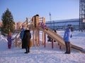 Children and parents ride in winter with a wooden slide