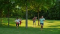 Children with parents running in summer park. Joyful family playing in meadow Royalty Free Stock Photo