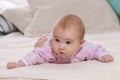 Portrait of cute baby girl lying on the bed at home. Royalty Free Stock Photo