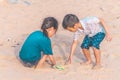 Children picking up Plastic bottle and gabbage that they found on the beach for enviromental clean up concept