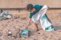 Children picking up Plastic bottle and gabbage that they found on the beach for enviromental clean up concept