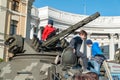 Children play on an armored vehicle of the Ukrainian army. Armored personnel carrier. Exhibition of military equipment in Kiev.