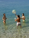 Children play with a ball in sea