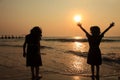 Children play at the beach during sunset