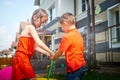 Children playing with garden sprinkler. Brother and sister running and jumping. Summer outdoor water fun in backyard Royalty Free Stock Photo