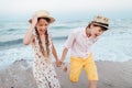 Children play and have fun on the beach. The girl and the guy run away from the waves Royalty Free Stock Photo