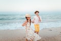 Children play and have fun on the beach. The girl and the guy run away from the waves Royalty Free Stock Photo