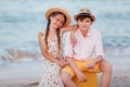 Children play and have fun on the beach. The girl and the guy run away from the wavesThe girl and the boy are sitting on a yellow Royalty Free Stock Photo