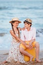 Children play and have fun on the beach. The girl and the guy run away from the wavesThe girl and the boy are sitting on a yellow Royalty Free Stock Photo