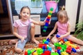 Children play at home with a plastic colored constructor. A child built a tower from parts of a children`s designer