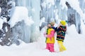 Children play with icicle in snow. Kids winter fun Royalty Free Stock Photo