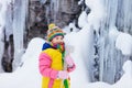 Children play with icicle in snow. Kids winter fun Royalty Free Stock Photo
