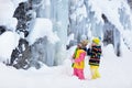Children play with icicle in snow. Kids winter fun Royalty Free Stock Photo