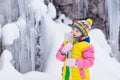 Children play with icicle in snow. Kids winter fun Royalty Free Stock Photo