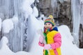 Children play with icicle in snow. Kids winter fun Royalty Free Stock Photo