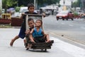 Children play with a makeshift wooden trolley at the Liwasang Bonifacio in front of the Manila Central Post Office in Lawton,