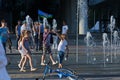 Children play near the fountain on the background of demobilized paratroopers, during the holiday of the Russian airborne troops.