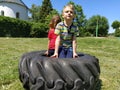 Children play and pick up the tire. Car parts and accessories in a kid`s game. A boy and a girl 6 and 7 years old are doing