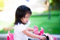 Children play pink electric toy motorcycle. A shabby-faced child. Kid made a suspicious expression. Royalty Free Stock Photo