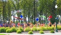 children play on playground with fountains in hot summer